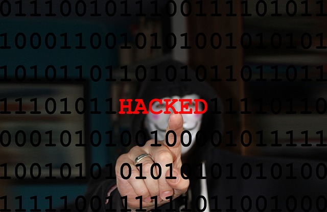 Maskierter Mann zeigt auf "hacked"